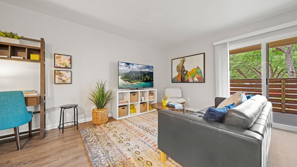 a living room with a couch and a chair and a desk with a chair