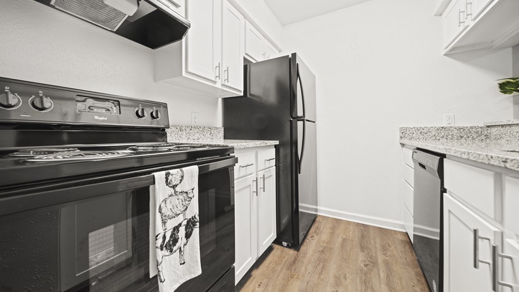 a kitchen with white cabinets and black appliances
