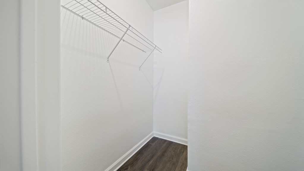 a bedroom with a medium hardwood floor and white walls