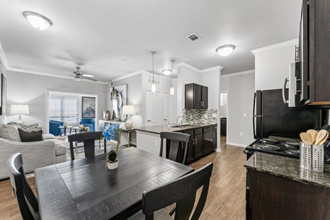 A modern kitchen with a black table and chairs.