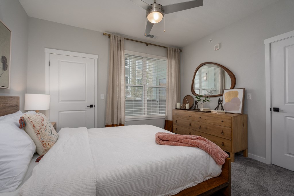 a bedroom with a bed and a dresser and a window