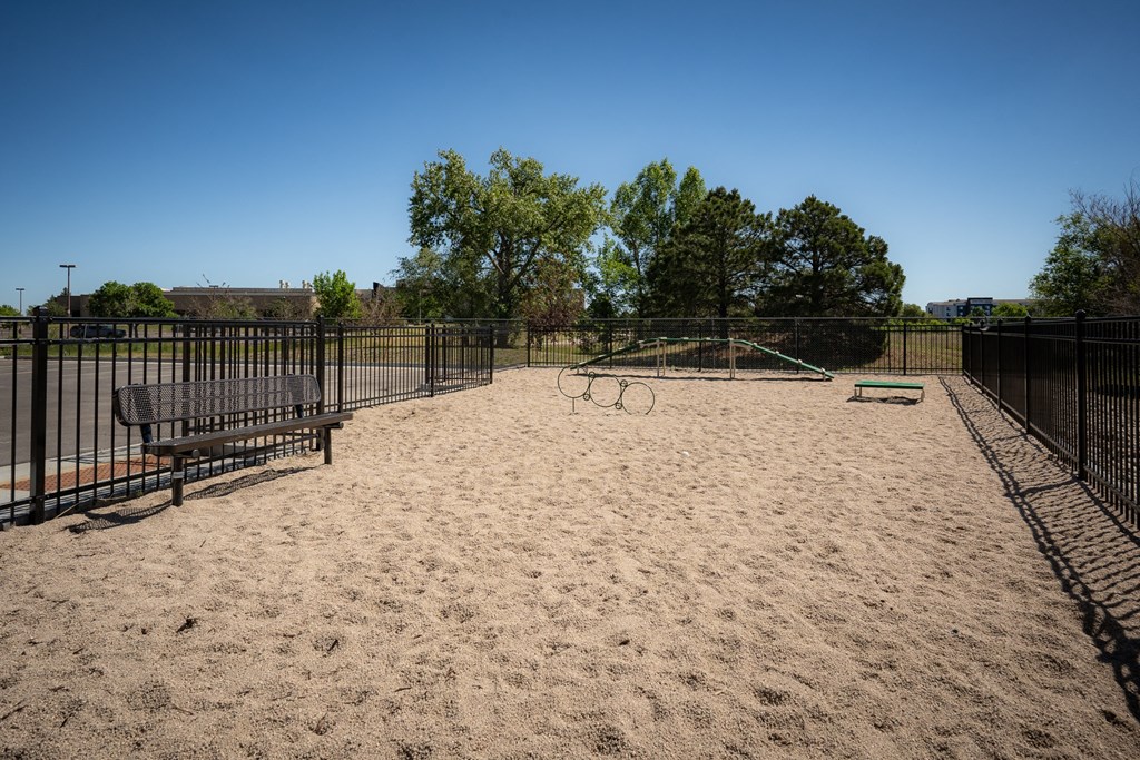 a playground with a bench and a swing set in a park