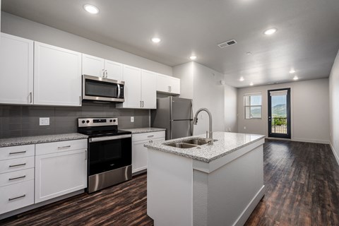 an empty kitchen with white cabinets and stainless steel appliances