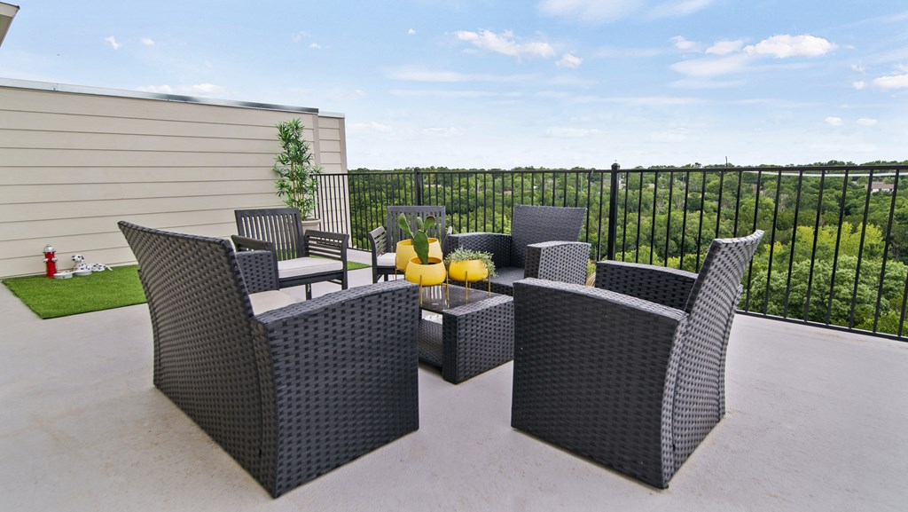 a patio with wicker furniture and a fire pit