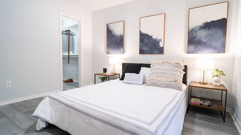 a bedroom with a large bed and paintings on the wall