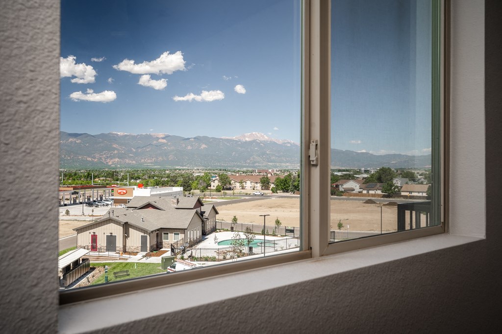 a view of the mountains from a window in a hotel room