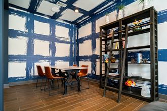 a room with blue paint on the walls and a white table and orange chairs