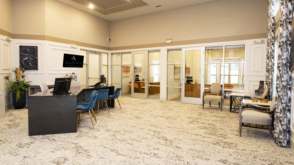 a large lobby with a desk and chairs and a computer