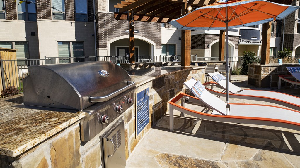 a large outdoor kitchen with a grill and a barbecue