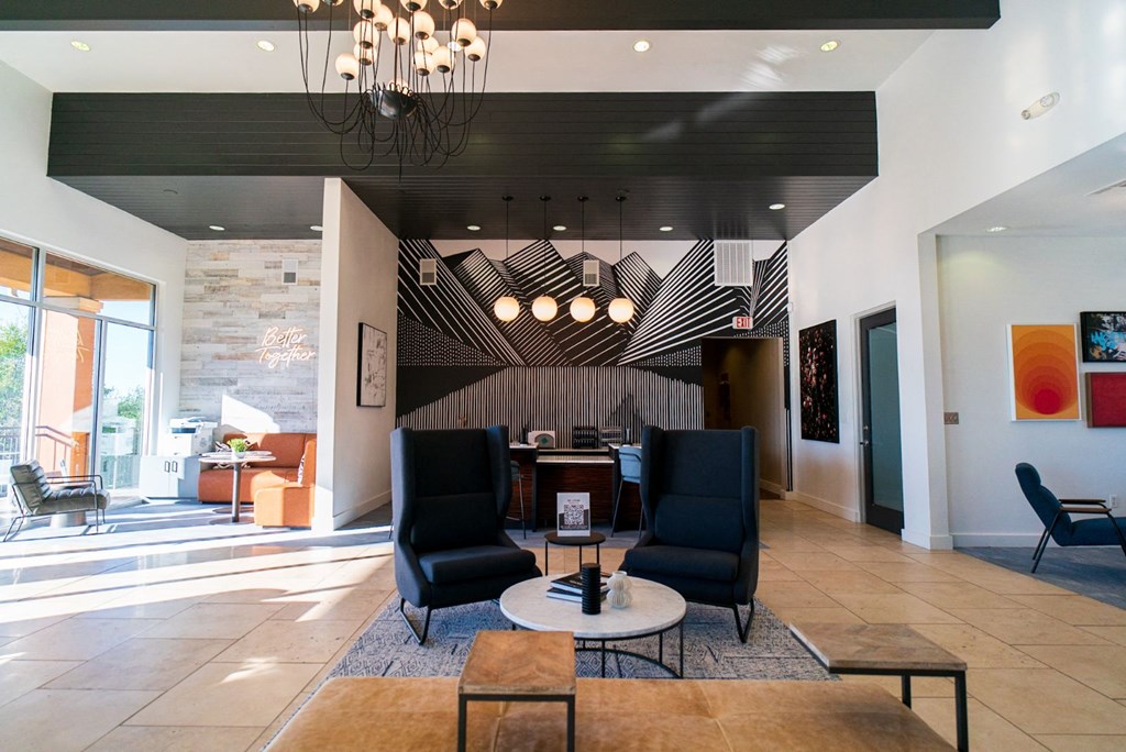 the lobby of a hotel with chairs and a table