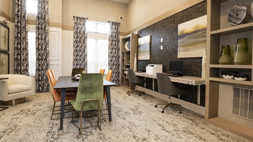 a dining room with a table and chairs and a desk with a computer