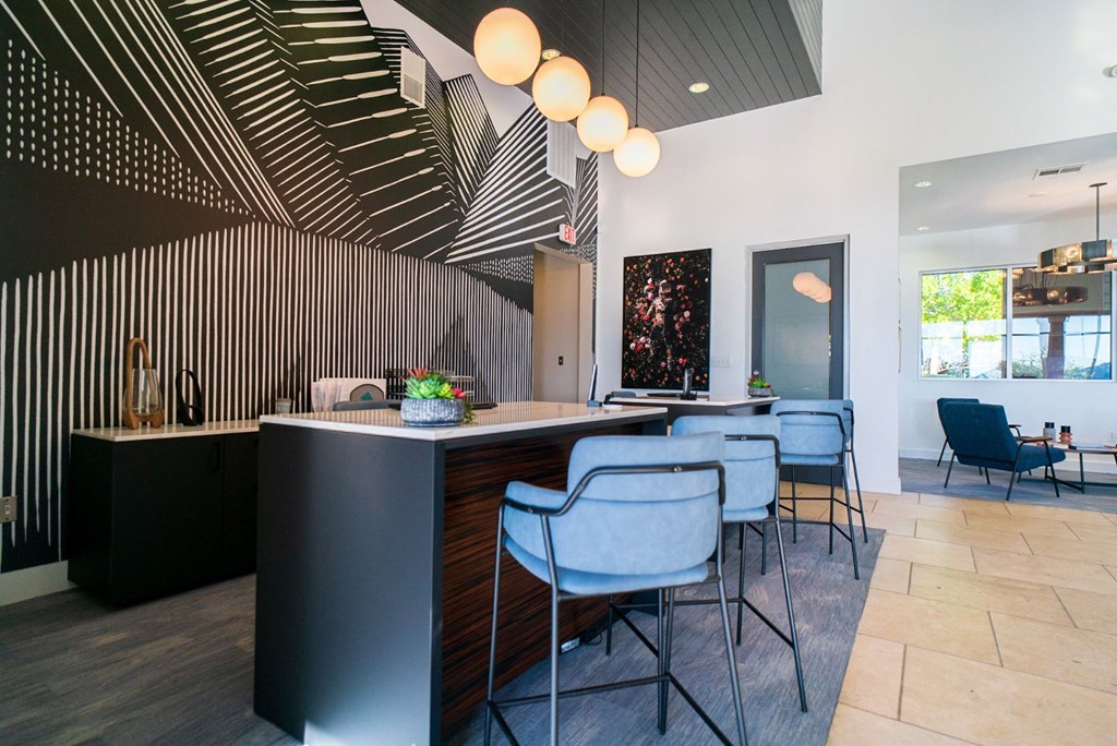 the kitchen and dining area of a modern house with blue chairs
