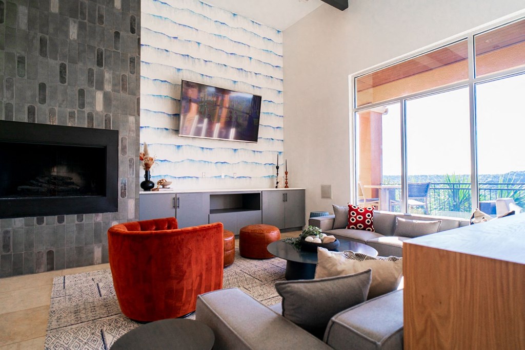 a living room with a stone wall and a fireplace