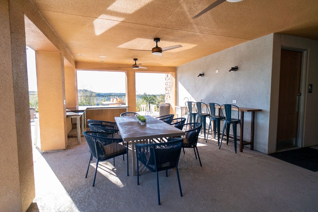 a large patio with a wooden table and chairs