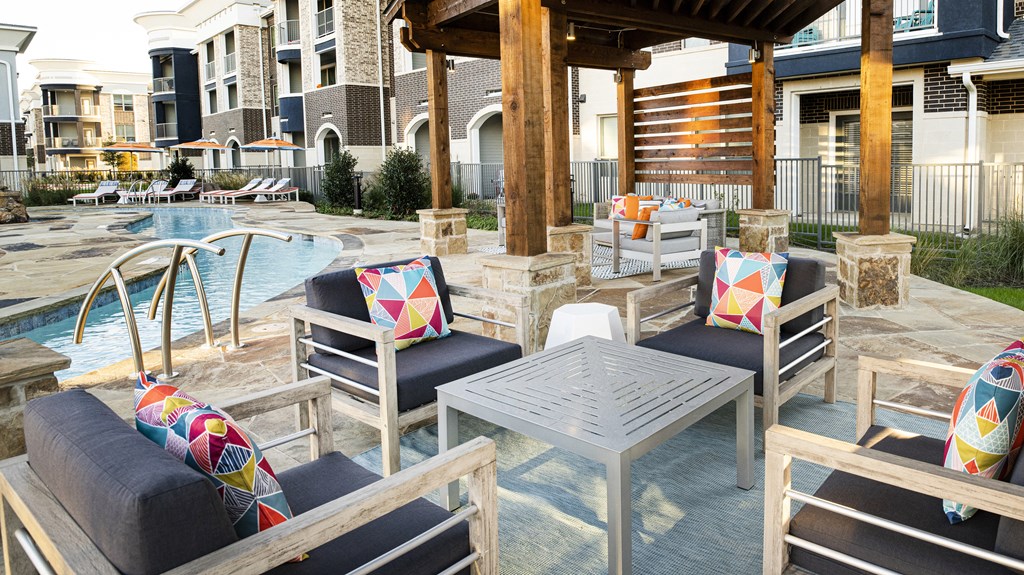a patio with chairs and tables and a swimming pool