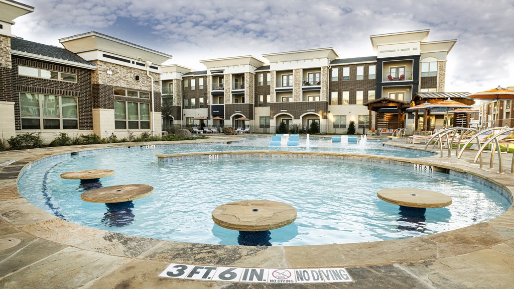 a large swimming pool in front of an apartment building