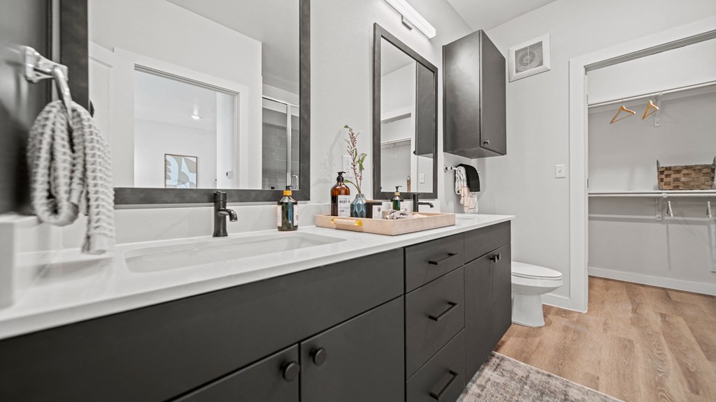 a bathroom with gray cabinets and white countertops