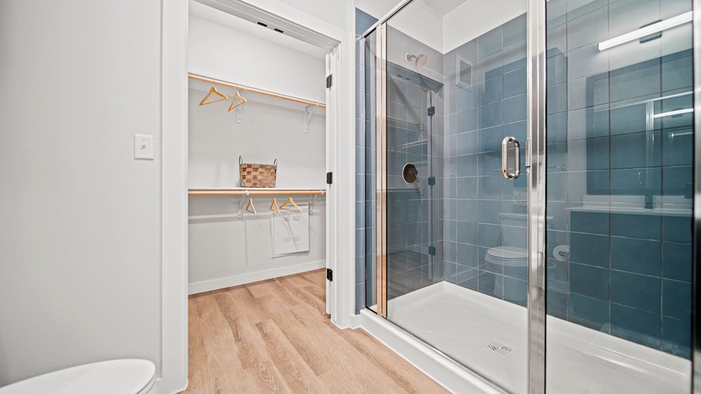 a bathroom with blue tiles and a glass shower door
