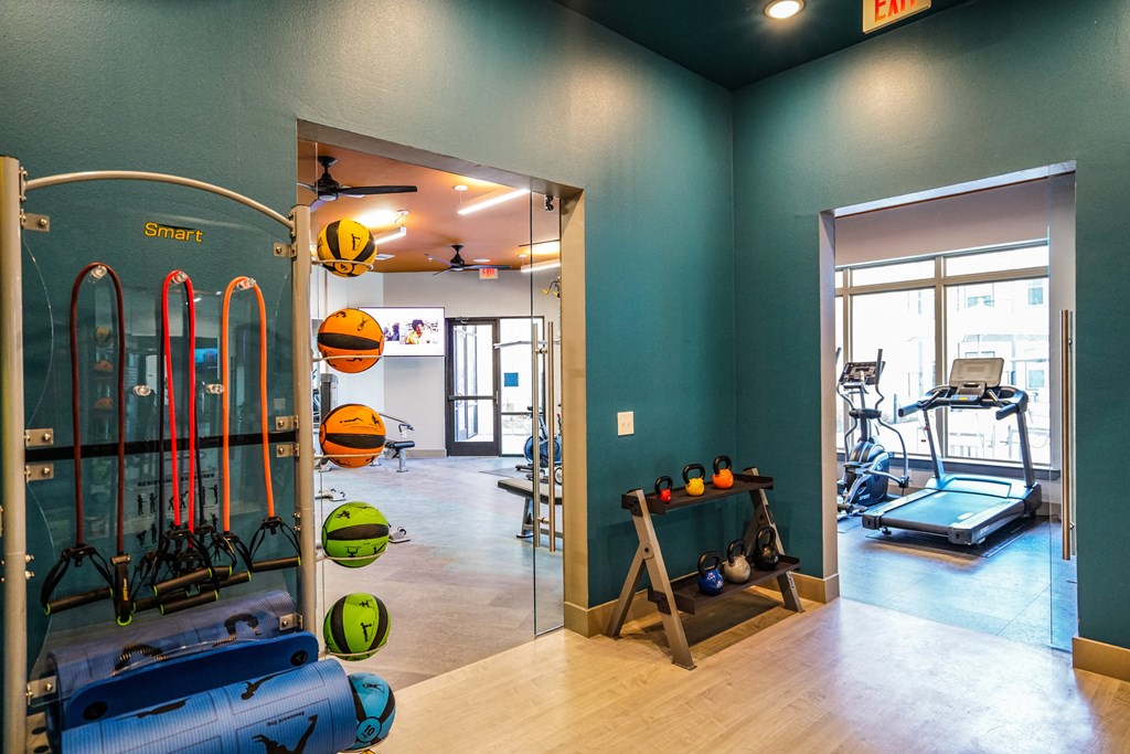 a gym with a lot of equipment and a glass door