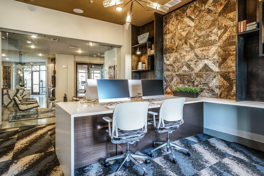a modern office with a long desk with three computer monitors