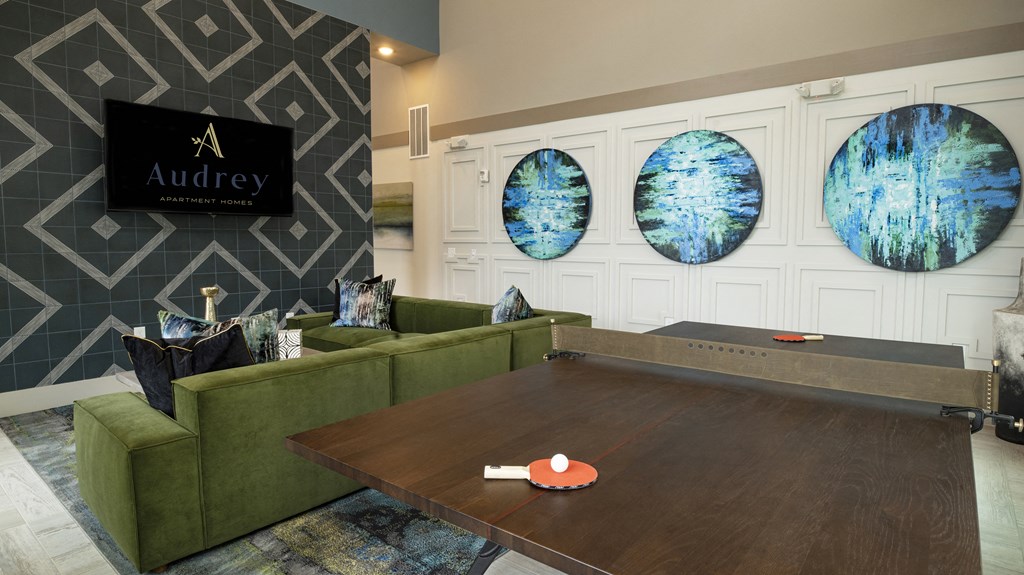 a conference room with couches and a table with three paintings on the wall