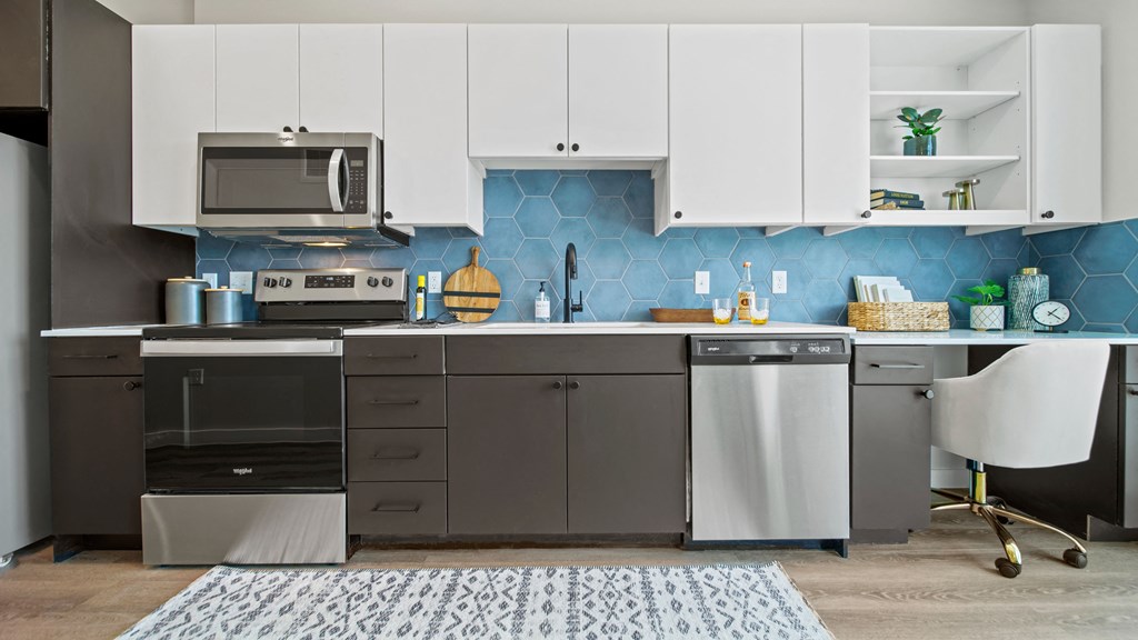 a kitchen with white cabinets and a blue accent wall
