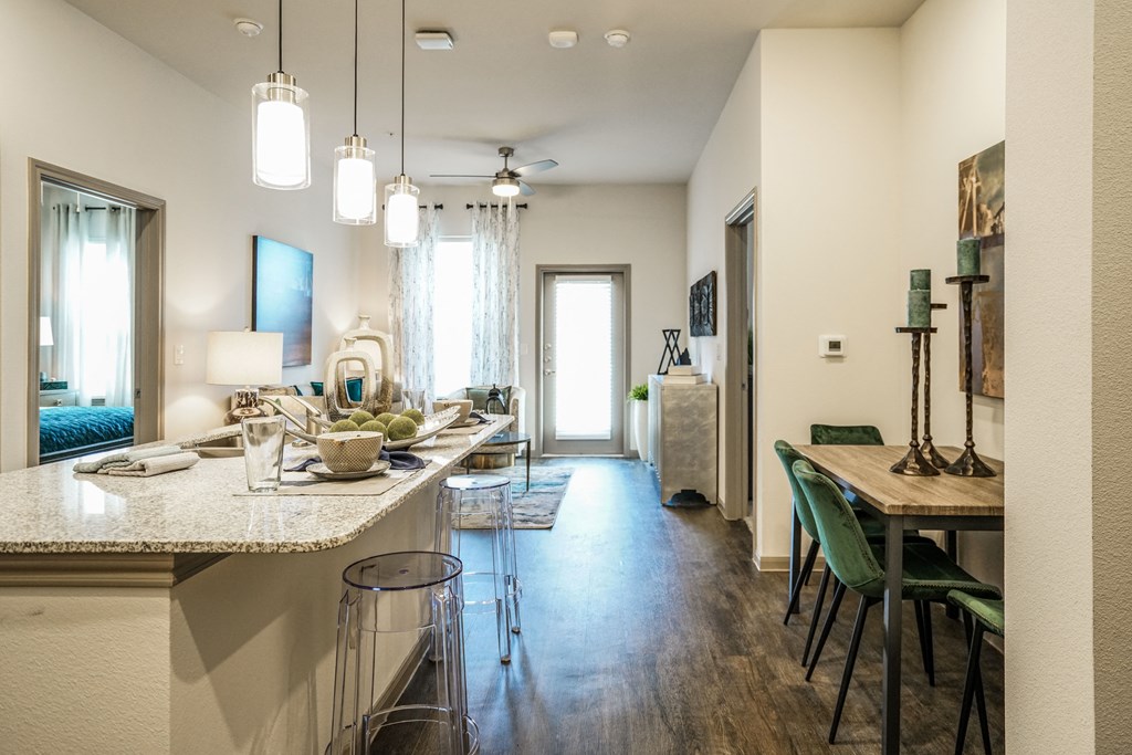 an open kitchen and living room with a dining room table and a kitchen counter top