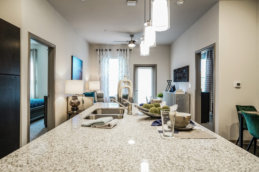 an open kitchen and living room with a large counter top
