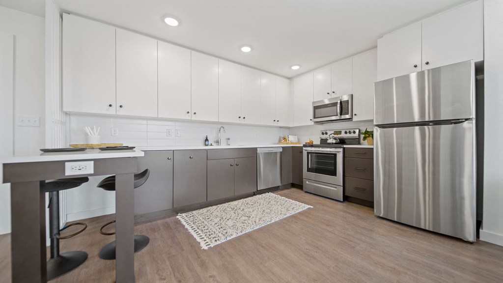 a kitchen with white cabinetry and stainless steel appliances