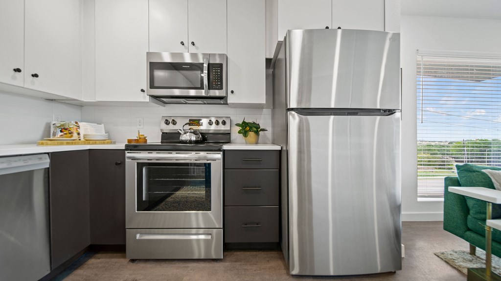 a kitchen with white cabinets and stainless steel appliances
