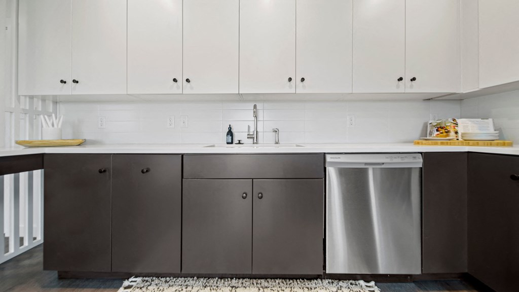 a kitchen with white countertops and gray cabinets