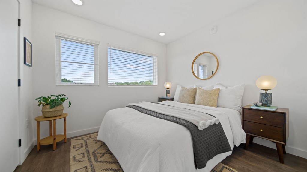 a bedroom with a bed and two windows