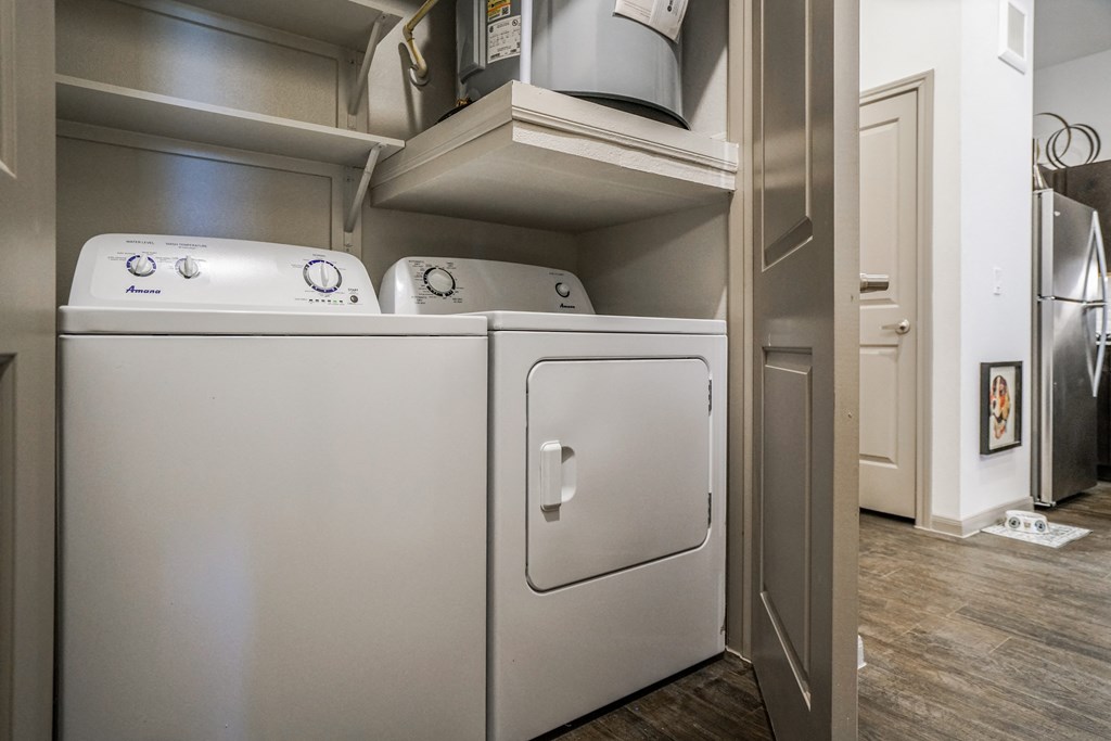 a washer and dryer in a laundry room with a cabinet above it