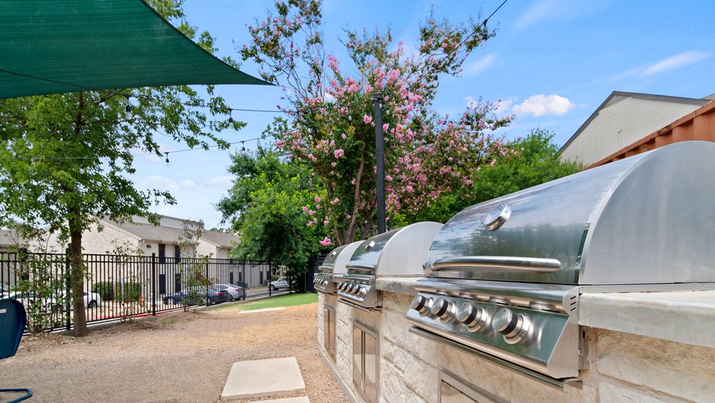 a barbecue grill with a green awning in front of a house