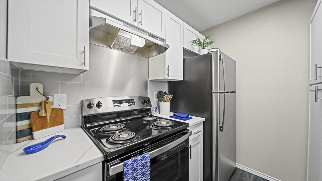 a kitchen with white cabinets and stainless steel appliances