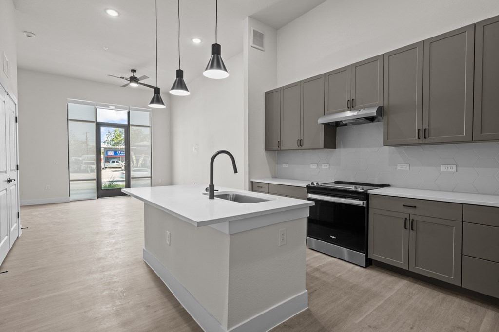 A modern kitchen with a white island and dark brown cabinets.