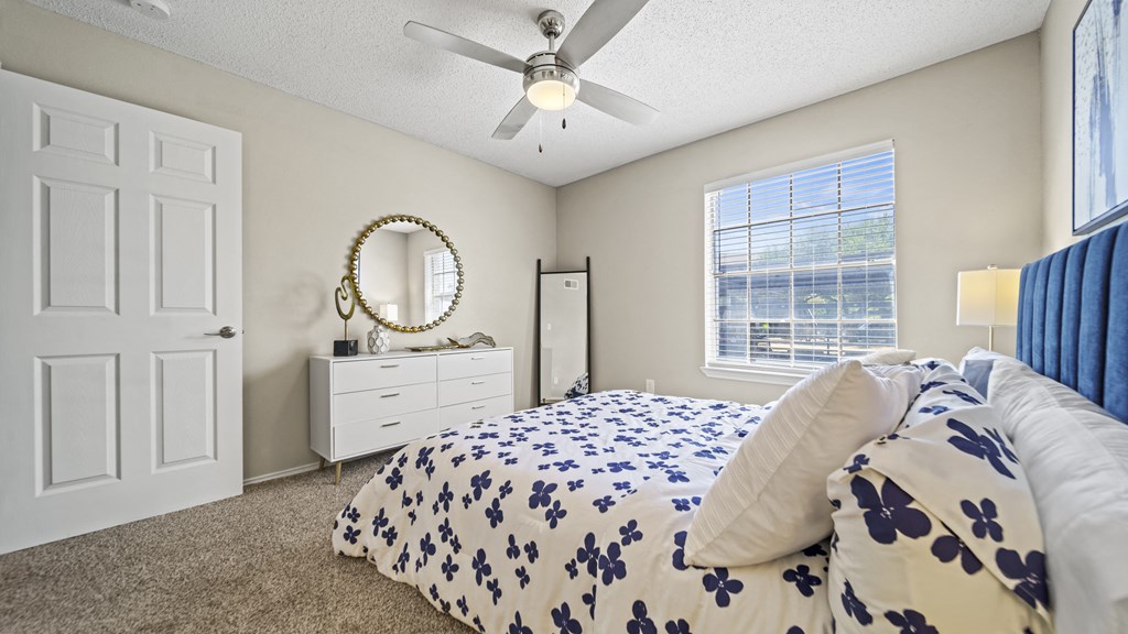a bedroom with a bed and a ceiling fan