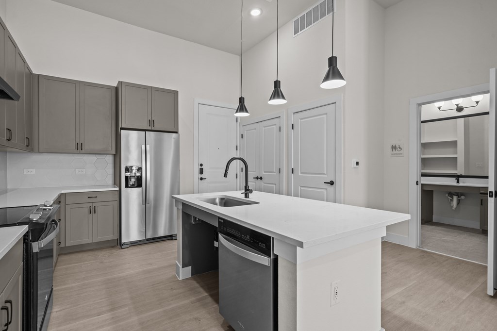 A modern kitchen with a white island and stainless steel appliances.