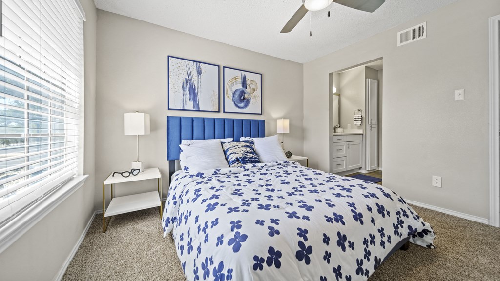 a bedroom with a bed and a ceiling fan