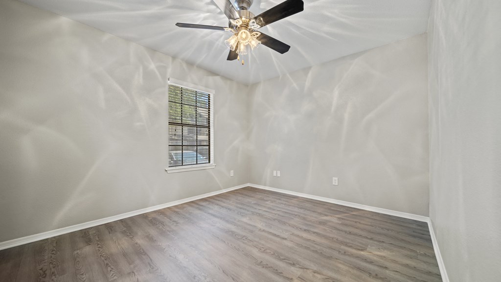 a bedroom with hardwood floors and a ceiling fan