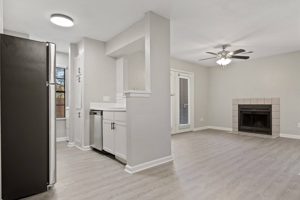 a living room with a fireplace and a kitchen