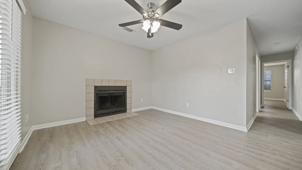 a living room with a fireplace and a ceiling fan