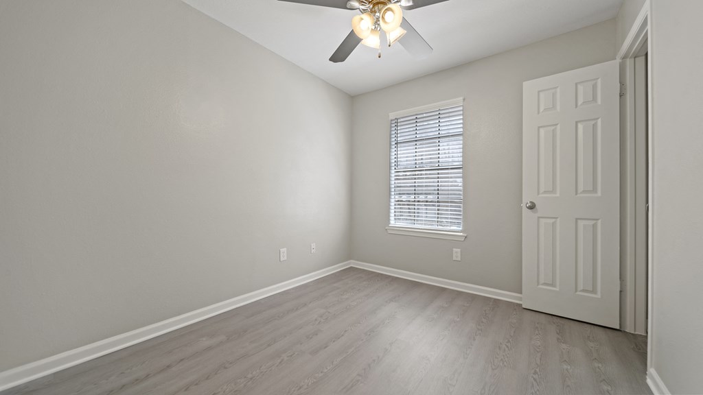 a bedroom with hardwood floors and a ceiling fan