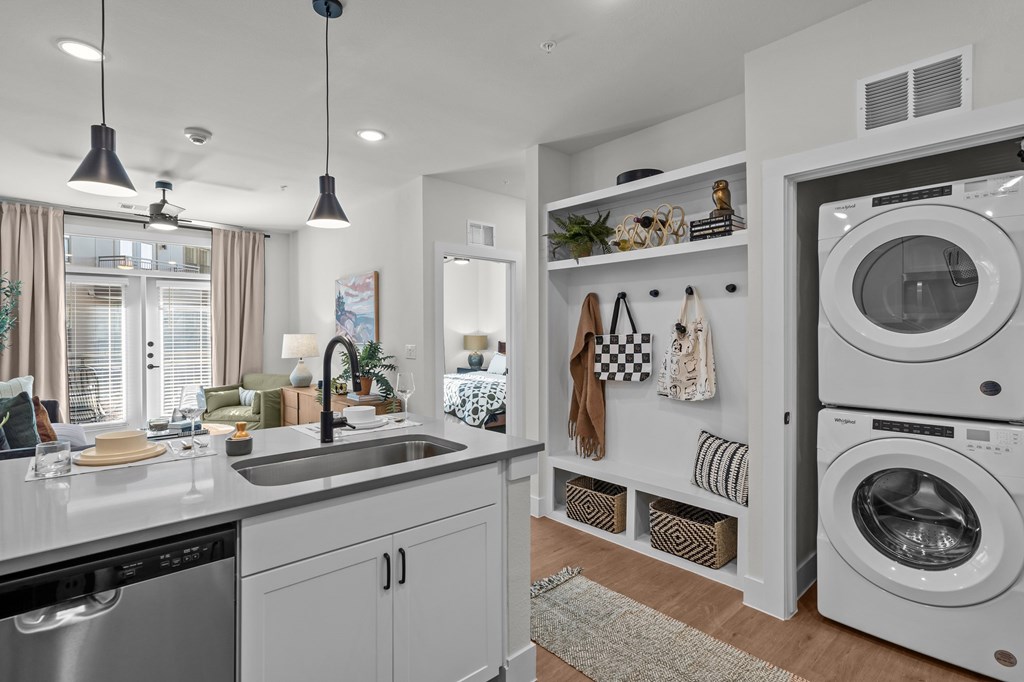 A modern kitchen with a washing machine and dryer built into the cabinetry.