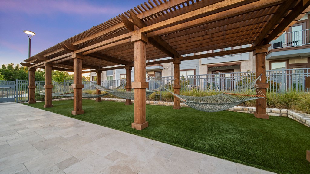 a patio with hammocks and a pergola