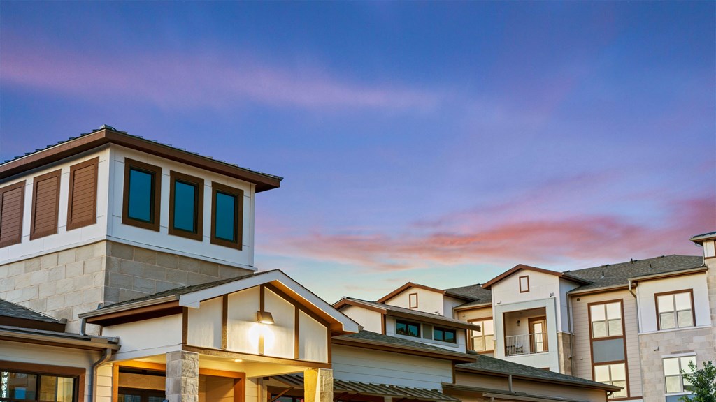 a row of houses with a sunset in the background