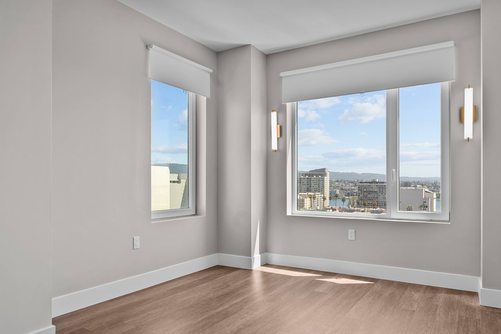 A room with two windows overlooking a cityscape.