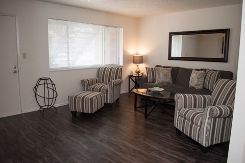 a living room with a couch and two chairs and a table