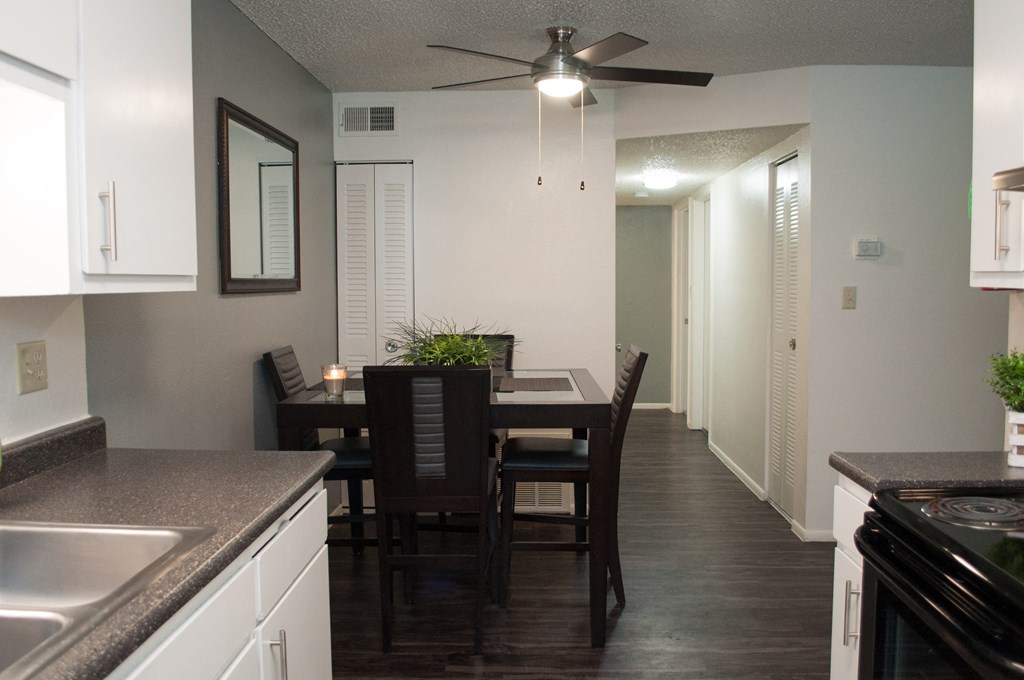 a kitchen and dining room with a table and chairs and a ceiling fan