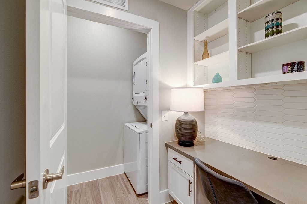 a laundry room with a washer and dryer and a desk